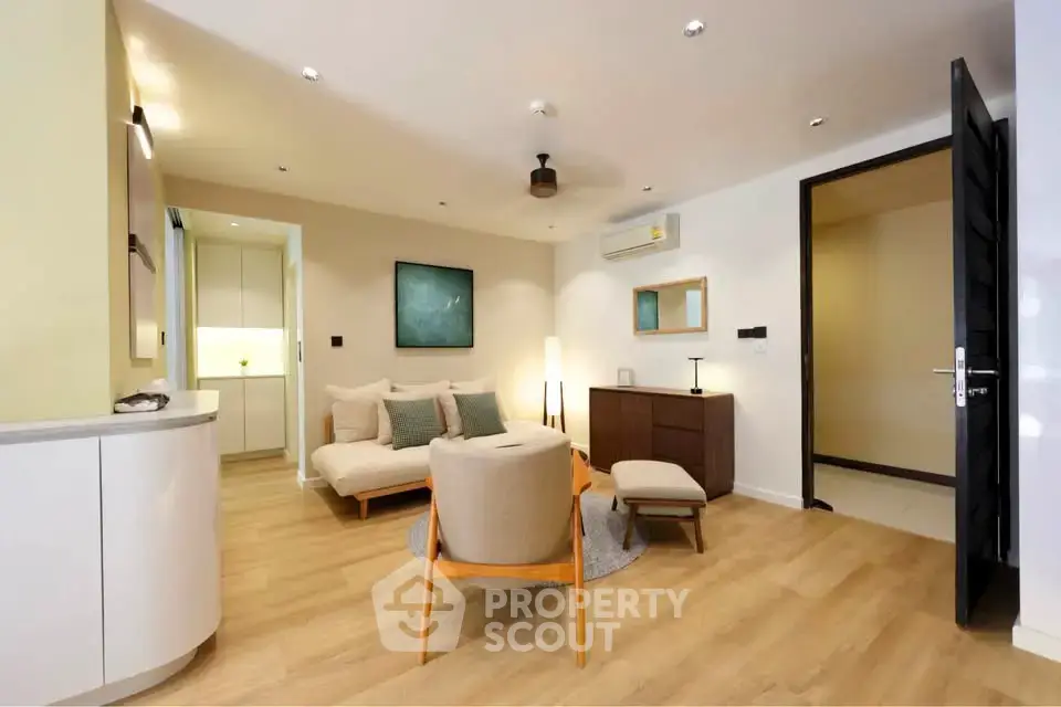 Modern living room with stylish furniture and open layout, featuring wooden flooring and contemporary decor.