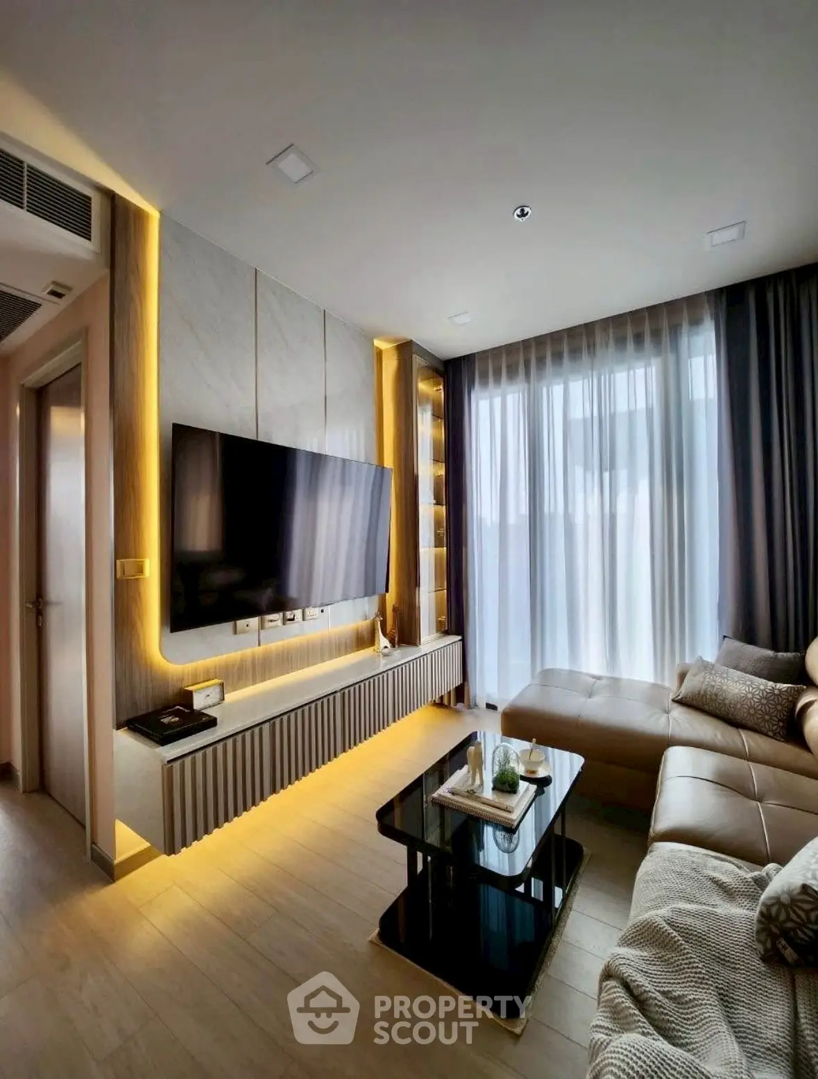 Modern living room with sleek design, large TV, and cozy seating area, perfect for relaxation and entertainment.