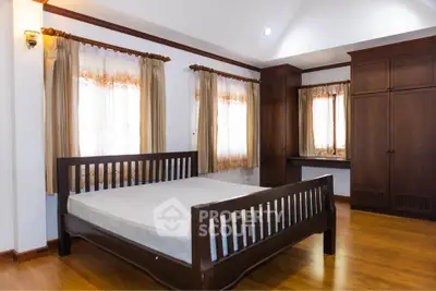 Spacious bedroom with wooden furniture and natural light