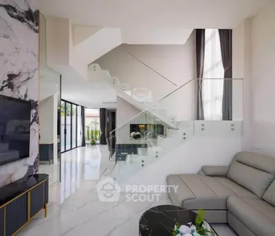 Luxurious modern living room with glass staircase and elegant marble accents