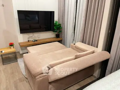 Modern living room with stylish sofa and large flat-screen TV, perfect for relaxation and entertainment.