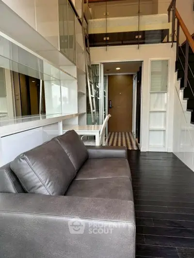 Modern loft-style living room with sleek design and mezzanine level.