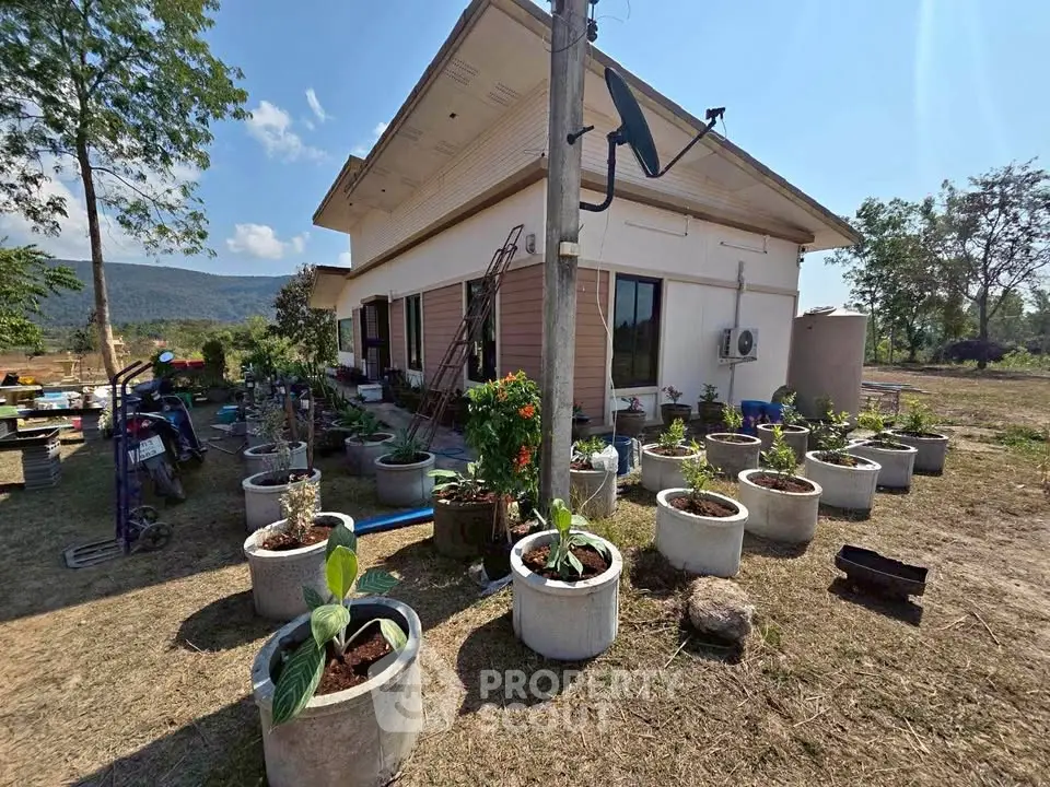Charming rural house with garden pots and scenic mountain backdrop