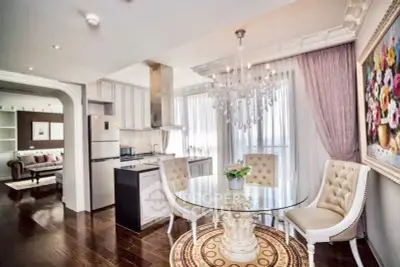 Luxurious open-layout kitchen and dining area with elegant chandelier and modern appliances.
