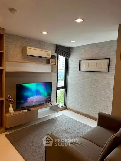 Modern living room with stylish decor and large window offering natural light.