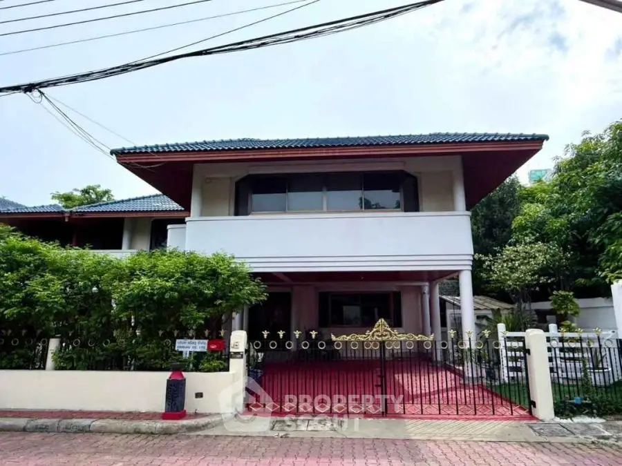 Charming two-story house with lush greenery and spacious driveway