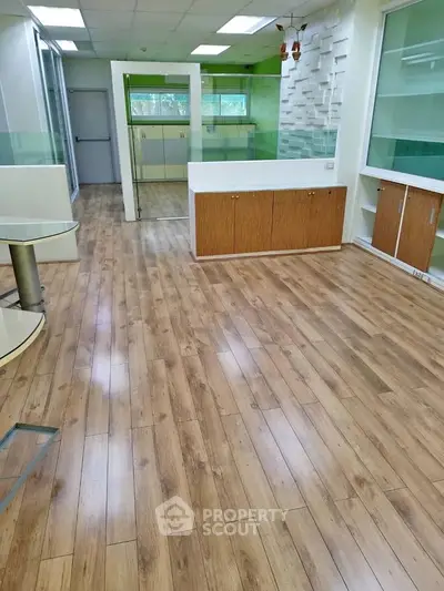 Spacious office interior with wooden flooring and modern design elements.