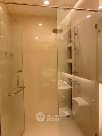 Luxurious modern bathroom with glass shower enclosure and elegant fixtures.