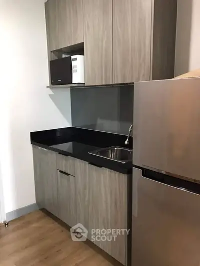 Modern kitchen with sleek cabinetry and stainless steel appliances in a compact layout.