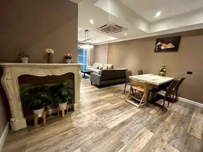 Elegant living room with stylish decor and cozy dining area, featuring modern flooring and ambient lighting.