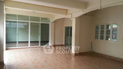 Spacious interior with tiled flooring and large windows, perfect for versatile use.