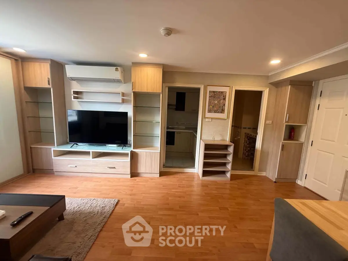 Spacious living room with modern wooden flooring and built-in entertainment unit