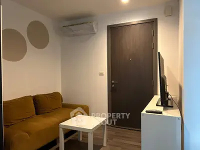 Cozy living room with modern sofa and TV setup, perfect for relaxation.