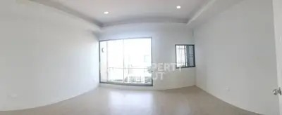 Spacious and bright empty room with large window and balcony access.