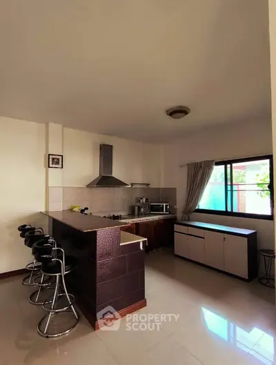 Modern kitchen with bar seating and natural light
