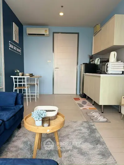 Modern living room with cozy decor, featuring blue sofa, stylish coffee table, and compact dining area.