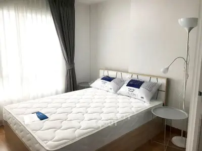 Cozy bedroom with natural light and modern decor, featuring a comfortable bed and stylish side tables.