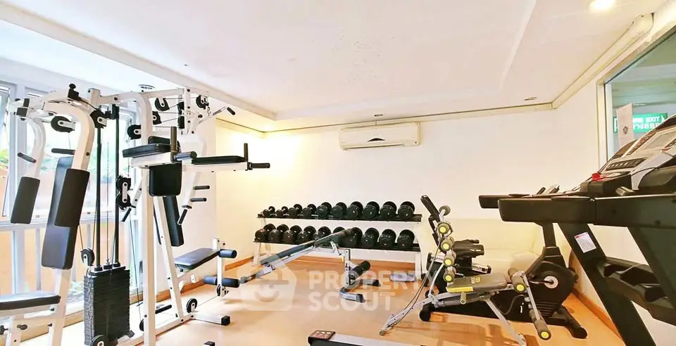 Spacious gym with modern fitness equipment in a well-lit room, perfect for a healthy lifestyle.