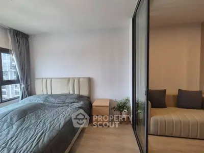 Modern bedroom with stylish decor and cozy seating area, featuring large windows for natural light.