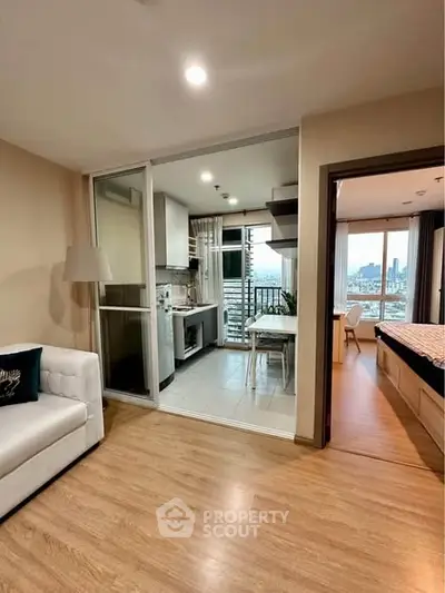 Modern apartment with open kitchen and city view, featuring sleek design and natural light.