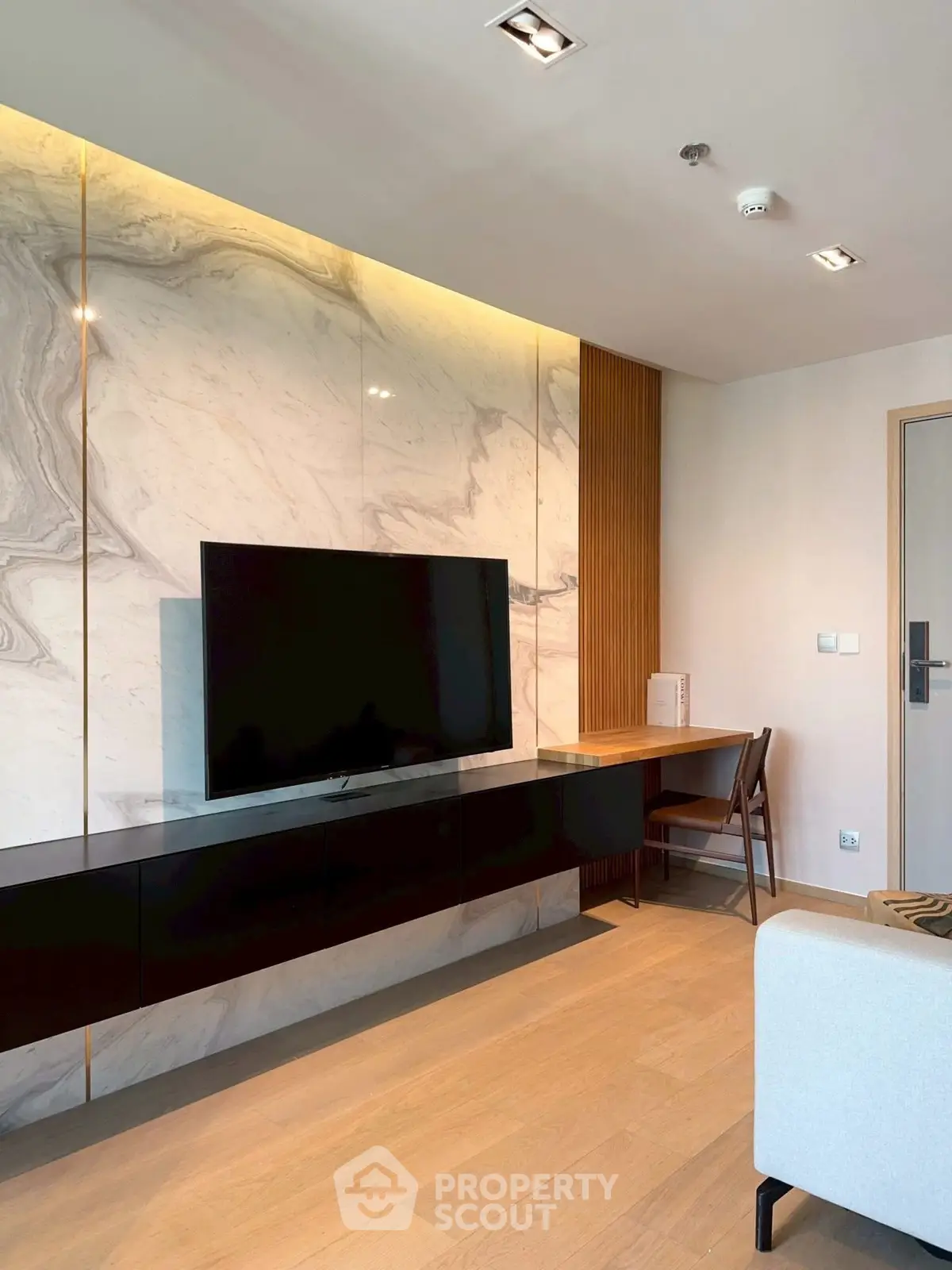 Modern living room with sleek TV setup and elegant marble wall design