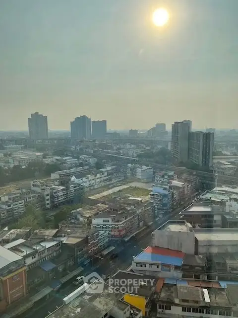 Stunning cityscape view from high-rise building showcasing urban skyline under a bright sun.