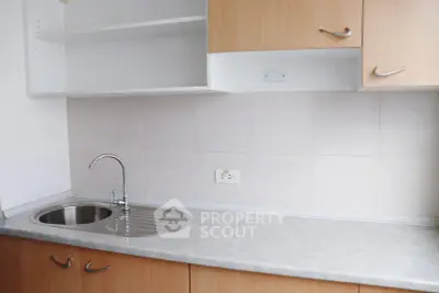 Modern kitchen with sleek countertop and stainless steel sink in a minimalist design.