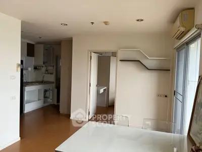 Modern apartment interior with open kitchen and dining area, featuring sleek design and ample natural light.