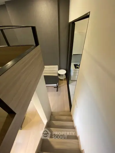 Modern loft-style apartment with wooden staircase and cozy living area