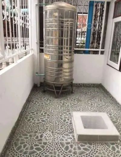 Spacious outdoor area with water tank and decorative tiled flooring