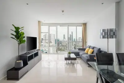 Modern living room with city view, sleek furniture, and abundant natural light.