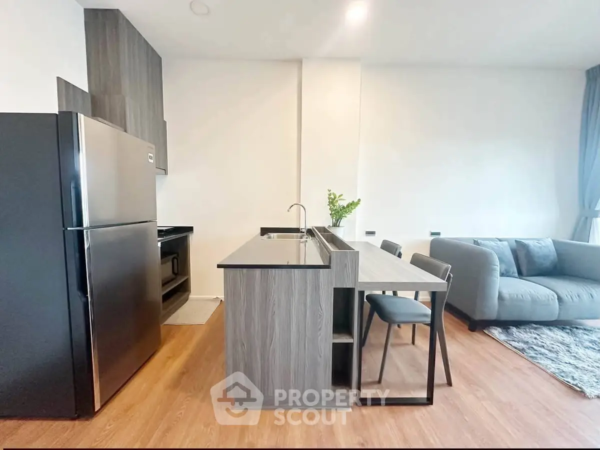 Modern open-layout kitchen and living room with sleek design and cozy seating area.