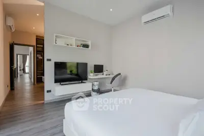 Modern bedroom with sleek design, featuring a wall-mounted TV and air conditioning.