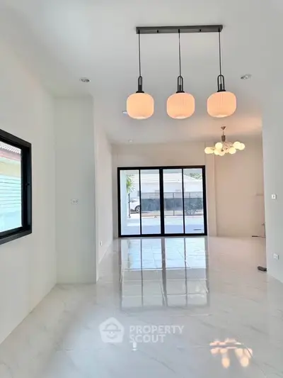 Spacious modern living room with elegant lighting and large windows for natural light.