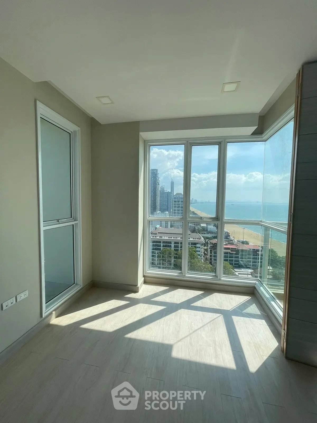 Bright corner unit with stunning ocean view and large windows in modern apartment.