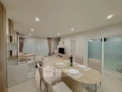 Spacious modern living room with dining area, elegant decor, and ambient lighting.
