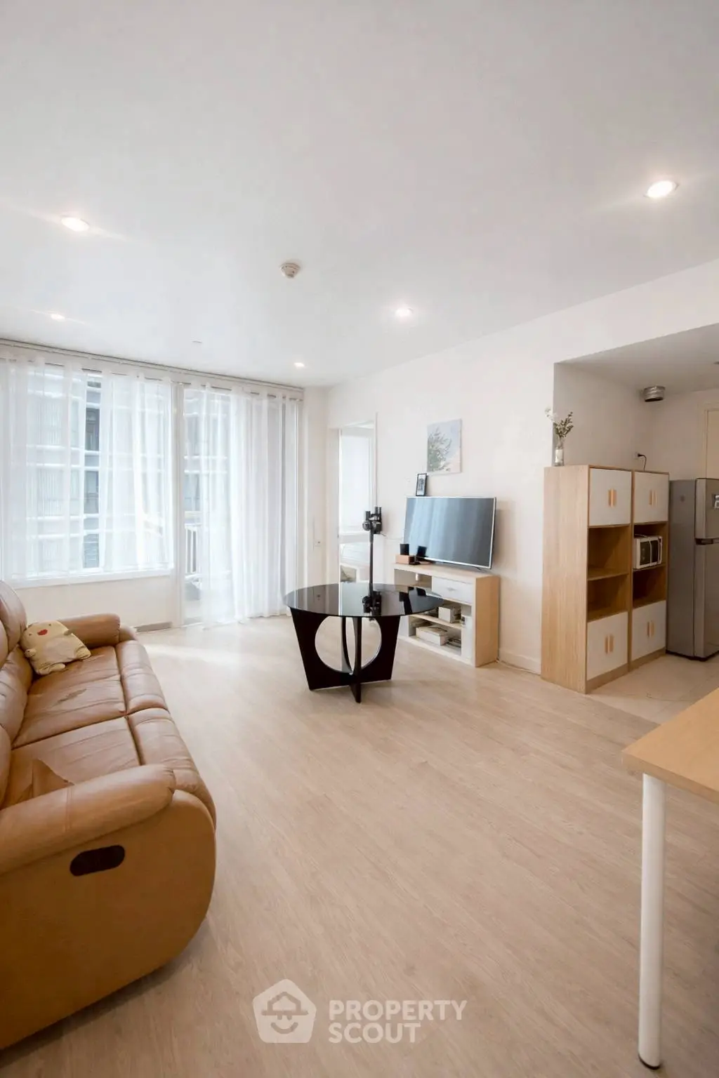 Bright and modern living room with leather sofa and sleek entertainment center