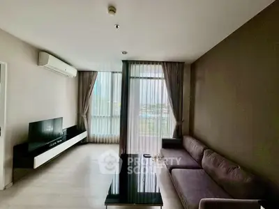 Spacious modern living room with large windows and elegant furnishings.