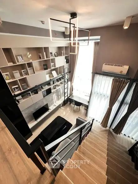 Modern loft-style living room with high ceilings and elegant staircase