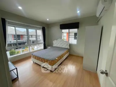 Bright bedroom with large windows and modern decor in a stylish home.