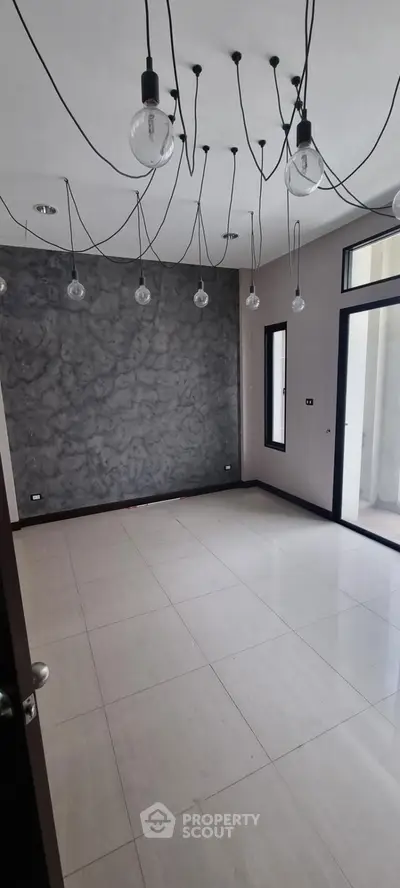 Modern empty room with unique lighting and marble accent wall, perfect for customization.