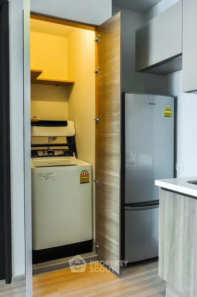 Modern kitchen with integrated washing machine and sleek refrigerator