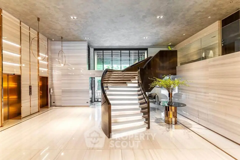 Luxurious building entrance with elegant staircase and modern design elements.