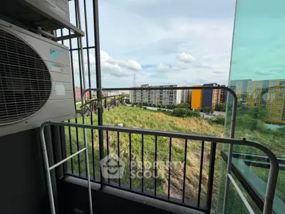 Charming balcony view with lush greenery and modern buildings, perfect for urban living enthusiasts.