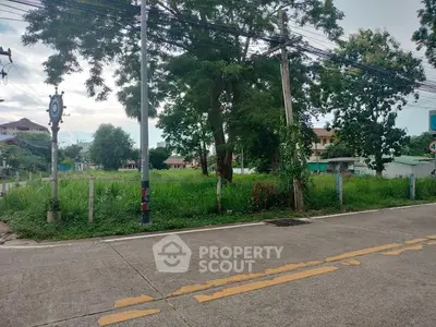 Vacant land plot with lush greenery and surrounding residential area