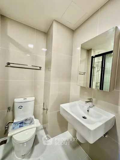 Modern bathroom with sleek fixtures and neutral tiles, perfect for a contemporary home.