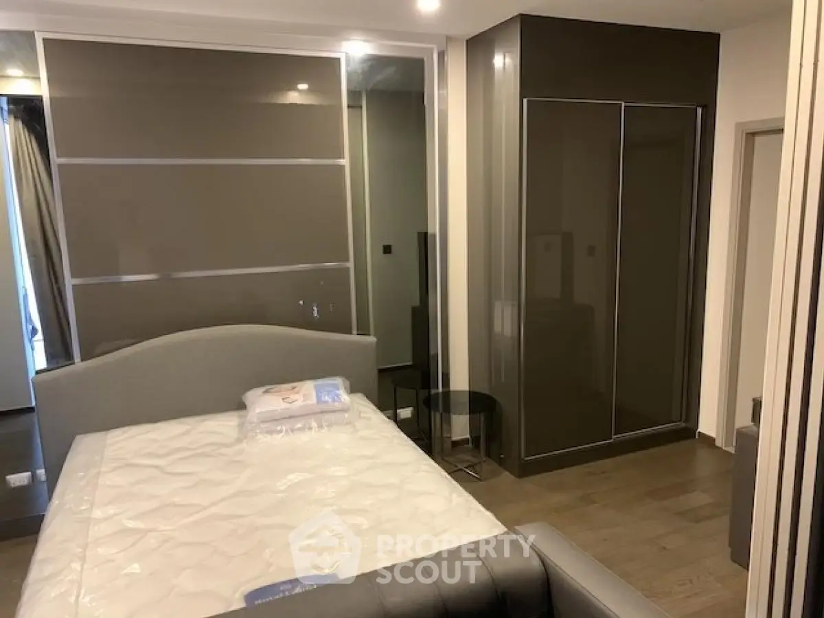 Modern bedroom with sleek design and ample storage space, featuring a stylish bed and built-in wardrobe.