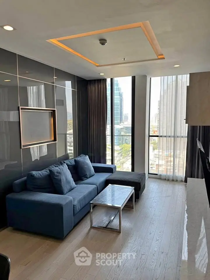Modern living room with sleek design and city view, featuring a stylish sofa and floor-to-ceiling windows.