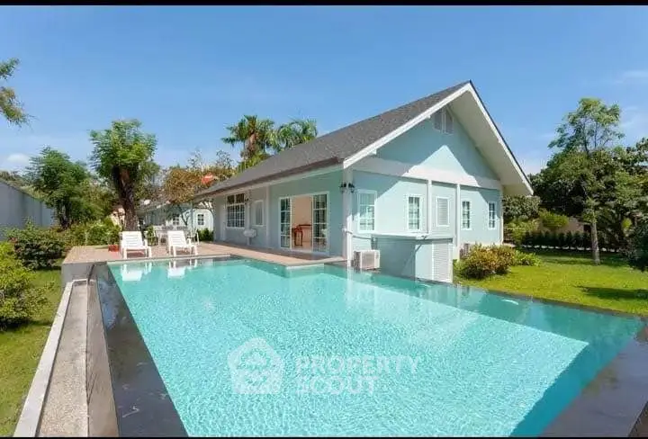 Charming blue house with a stunning pool and lush garden, perfect for relaxation and entertaining.