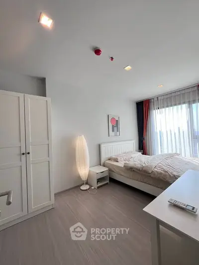 Bright and modern bedroom with large window and stylish decor